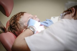 A dentist checking a child’s teeth