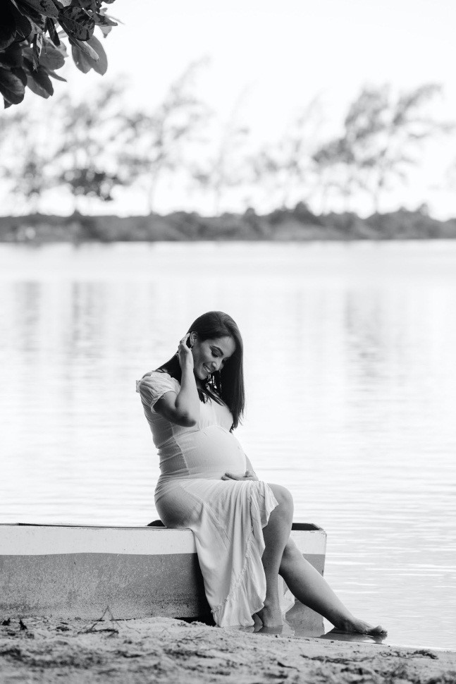 pregnant woman smiling in a white dress