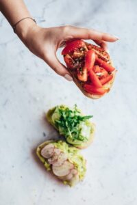 woman keeping roasted sandwiches on a white marble surface