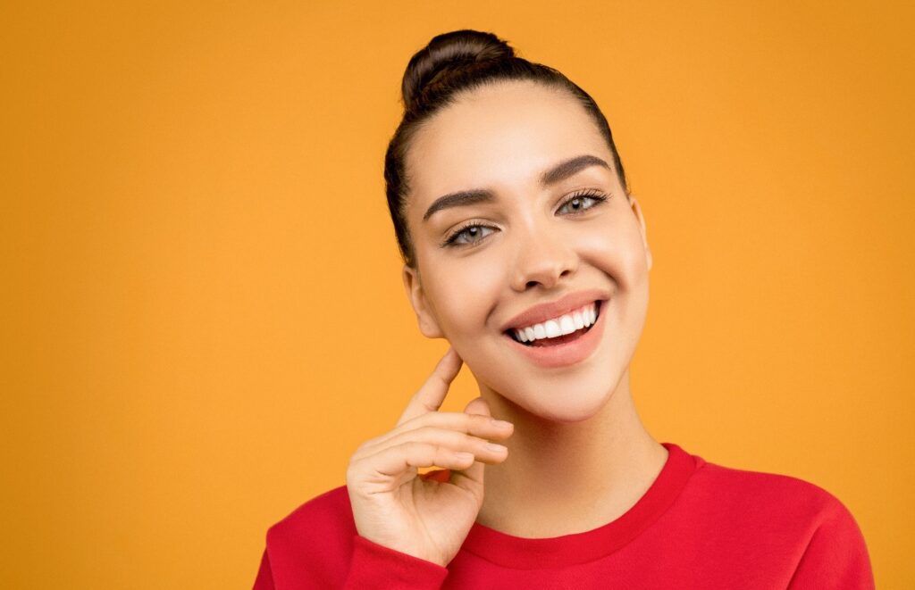 a woman wearing a red shirt sniling widely