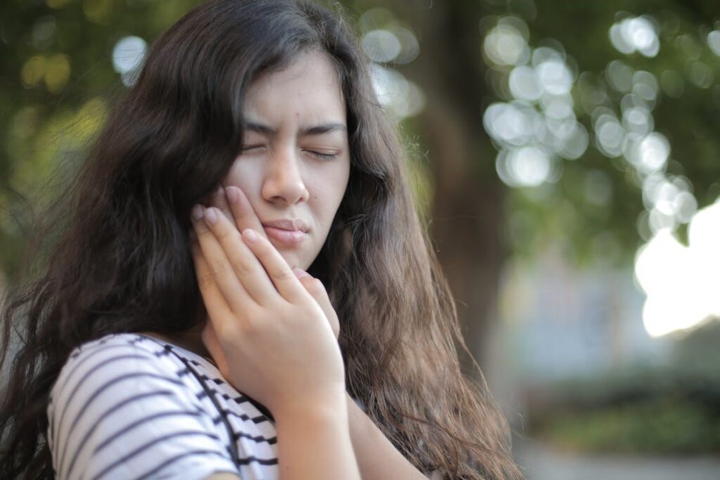 A girl with a hand on her face because of a toothache.