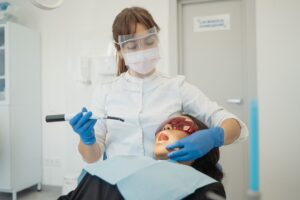 A dentist treating the patients' teeth with advanced equipment.
