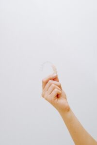 a hand holding clear aligners