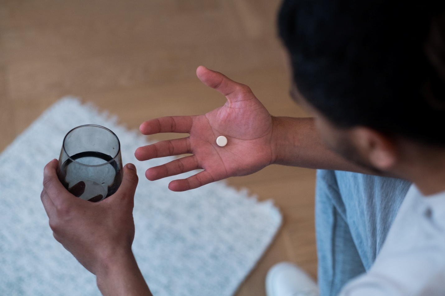 A person taking painkiller medication given by a dentist in West Hills, CA.