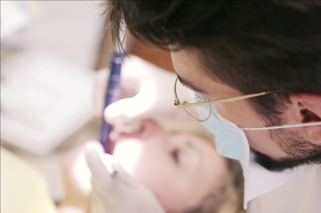 A dentist and a nurse are treating a sedated patient