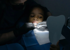 A young patient receives dental treatment by professional