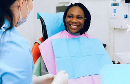 A patient smiles at her dentist after professional teeth whitening procedure