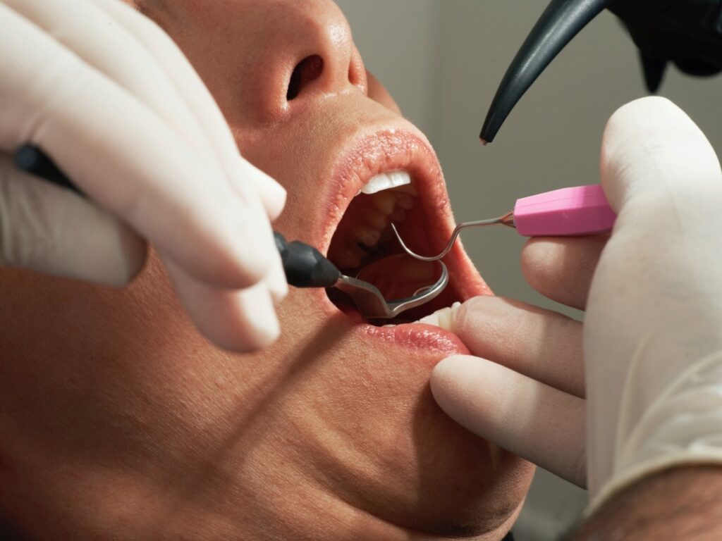 A dentist examining a patient’s gums