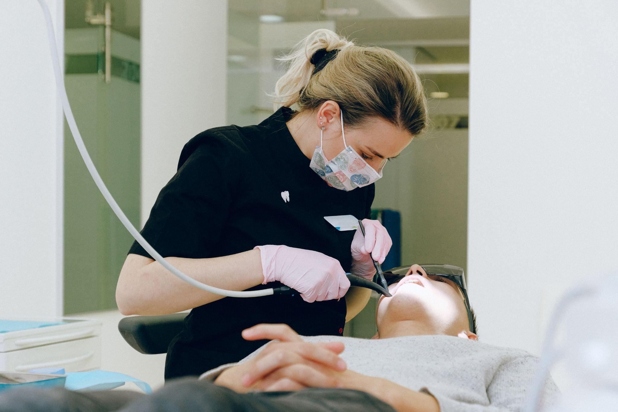 A dentist is giving dental treatment to a boy