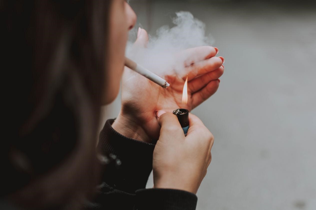 A woman lighting a cigarette with a lighter