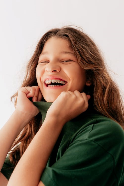 An image of a woman in a green shirt smiling  