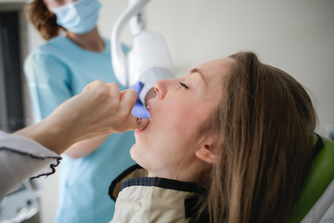 A woman in a dental clinic touching her teeth