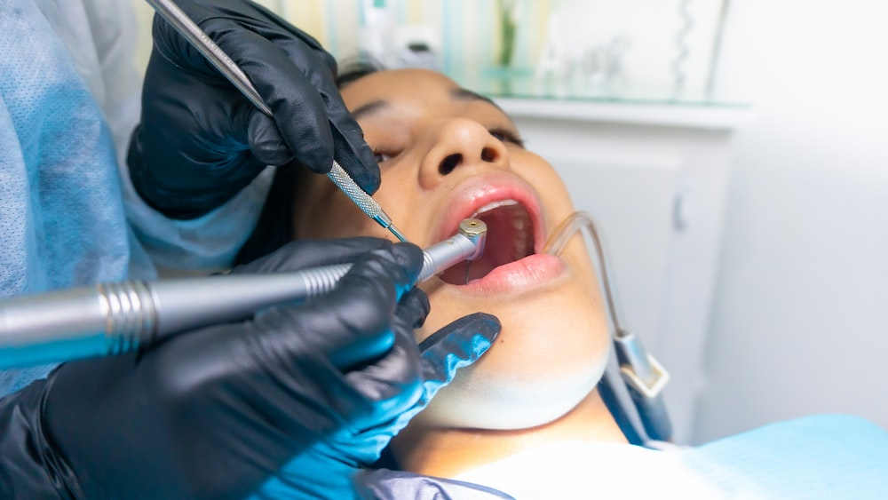 A closeup of a female patient having a deep dental cleaning service