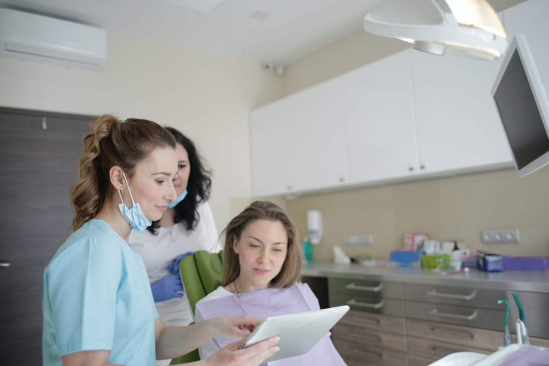 A dentist and a patient having a discussion before a dental treatment