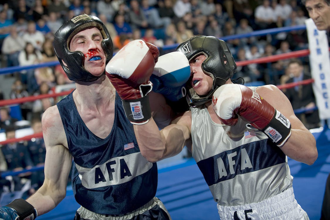 Two boxers boxing in a ring while wearing custom sports mouthguards