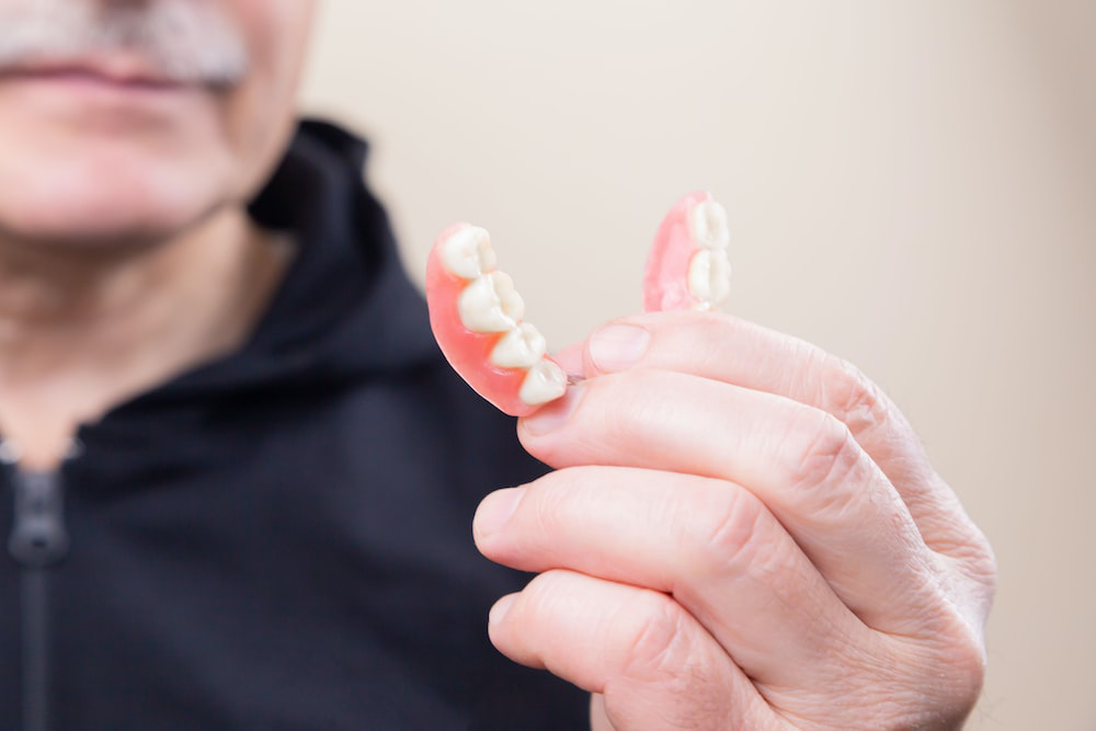 An image of a man holding a teeth-shaped item